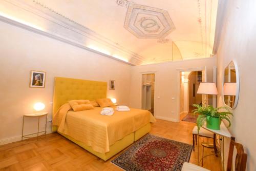 a bedroom with a yellow bed and a ceiling at LA CASA DI MONIC in Pisa