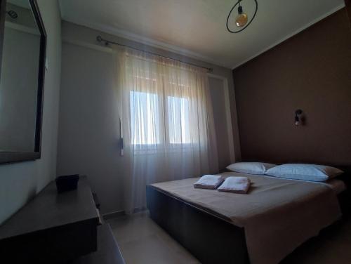 um quarto com uma cama com duas toalhas em A & F Apartments - Fay's house em Kalivia Poligirou