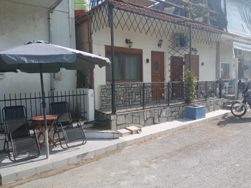 a table and chairs and an umbrella outside a house at argiri appartments in Olympiada