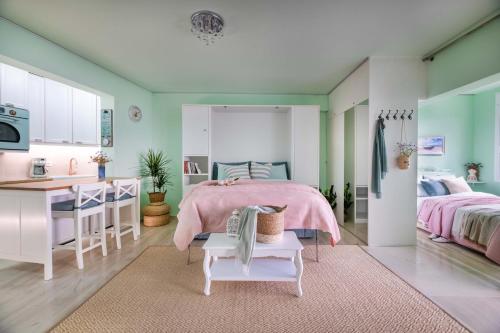 a bedroom with a pink bed and a kitchen at Lydia's Luxury Apartment in Loutraki