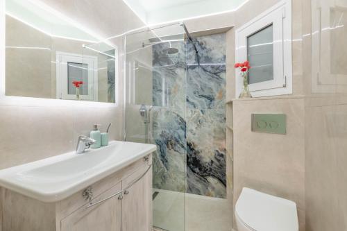 a bathroom with a sink and a shower at Lydia's Luxury Apartment in Loutraki