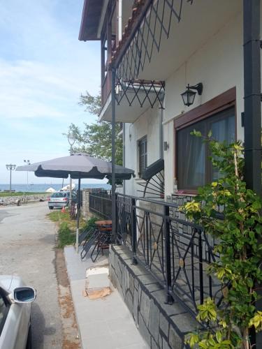 a patio with tables and umbrellas on the side of a building at argiri appartments in Olympiada