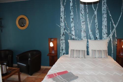 a bedroom with a bed with a blue wall at LE LIT QUI DANSE in Mollans-sur-Ouvèze