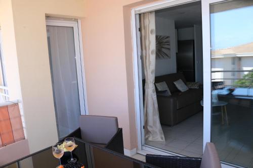- un salon avec un canapé et une porte en verre dans l'établissement Port-Fréjus, LE CONSUL, appartement 2 pièces climatisé, terrasse & parking, à Fréjus