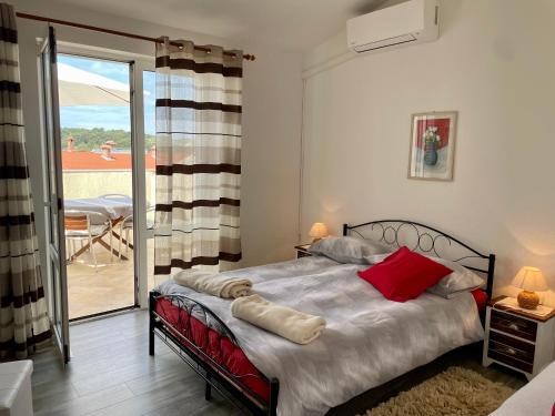 um quarto com uma cama e uma porta de vidro deslizante em Apartments Maričić Banjol em Rab