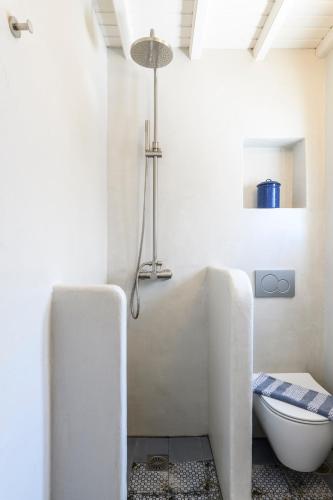 a white bathroom with a tub and a toilet at Mykonos Perla Town House in Mikonos