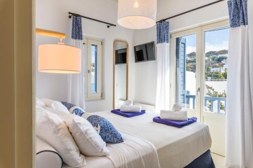 a bedroom with a bed with a window at Mykonos Perla Town House in Mikonos