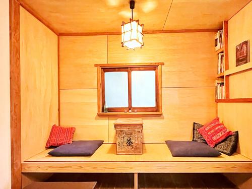 a room with a window and a bench with pillows at Sai Holiday House Ohama Beach - Max 9 ppl in Shimoda