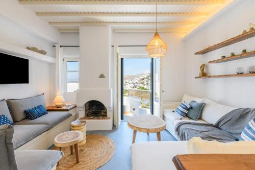 Una sala de estar con un sofá y una chimenea. en Mykonos Perla Town House, en Mykonos ciudad