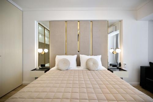 1 dormitorio con 1 cama grande con almohadas blancas en Infinity Everglow Apartment Spa&Pool Beach Resort-parking en Mamaia