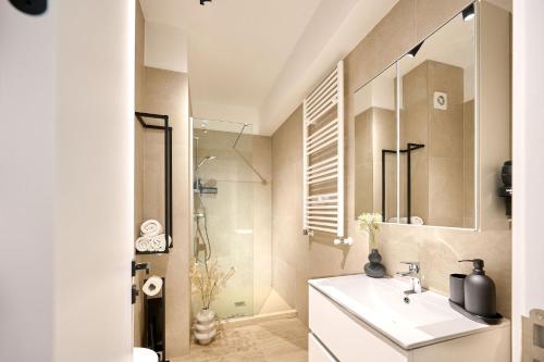 y baño blanco con lavabo y ducha. en Infinity Everglow Apartment Spa&Pool Beach Resort-parking, en Mamaia