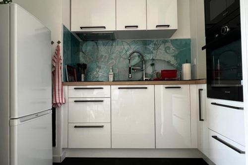 une cuisine avec des armoires blanches et un évier dans l'établissement Apartment near the city center, à Andernos-les-Bains