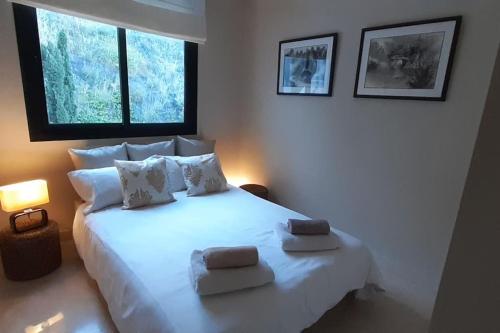 - une chambre avec un lit blanc et 2 serviettes dans l'établissement Chic Beachfront Apartment, à Torrox Costa