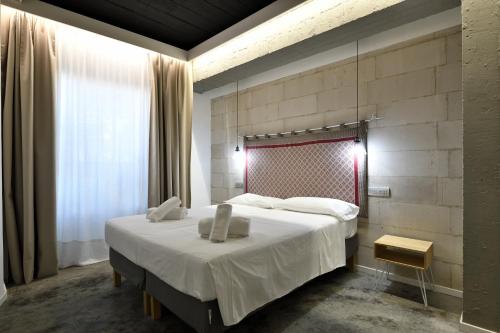 een slaapkamer met een groot bed en een raam bij Loft incantevole con piscina in Tortolì