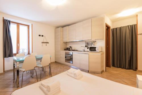 eine Küche und ein Esszimmer mit einem Tisch und Stühlen in der Unterkunft La Filanda Apartments by Wonderful Italy - Cotone in Bellagio