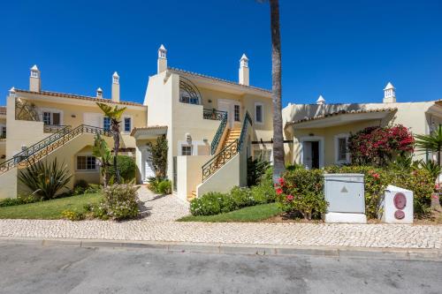 a large white house with stairs and flowers at Apartment Presa de Moura in Carvoeiro