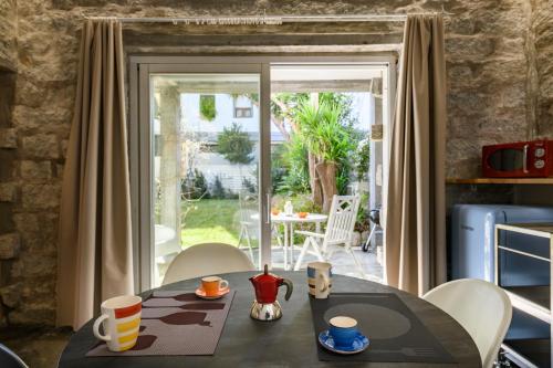een eetkamer met een tafel en stoelen en een patio bij Loft incantevole con piscina in Tortolì
