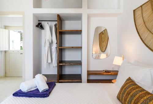 a bedroom with a white bed and a mirror at Supreme Mykonos Town House with Views & Pool & Parking in Mýkonos City