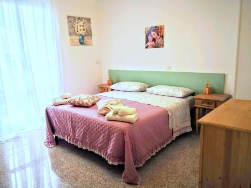 um quarto com uma cama com um cobertor rosa em Appartamento vacanze Assisi nel cuore em Costano