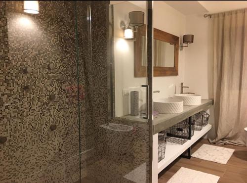 a bathroom with a shower with two sinks and a mirror at Guest house Festinalente in Montegrotto Terme