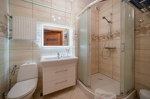 a bathroom with a toilet sink and a shower at Aquapark Health Resort & Medical SPA Panorama Morska All Inclusive in Jarosławiec