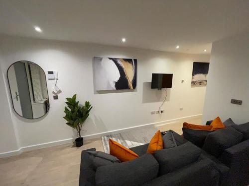a living room with a couch and a tv at 1-Bedroom Apartments in the Heart of Central Woking in Woking