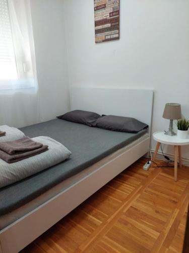 een bed in een witte kamer met een tafel bij Smiley 2 - Subotica Centar in Subotica