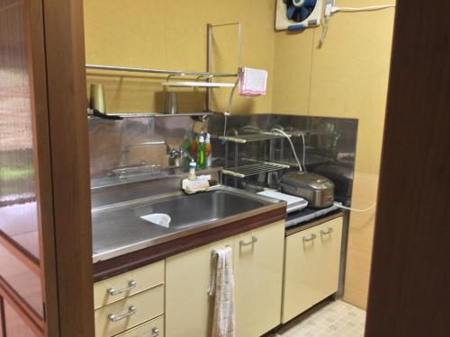 uma cozinha com um lavatório e um fogão em ゲストハウス Rei em Hongu
