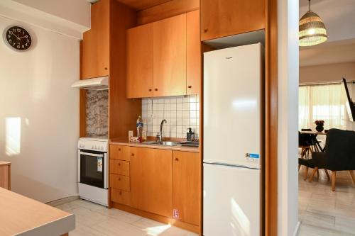 a kitchen with wooden cabinets and a white refrigerator at Thessaloniki Center Modern Apartment in Thessaloniki
