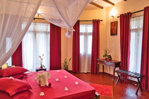 a bedroom with a pink bed with an elephant on it at Sri Lancashire Guest House in Bentota