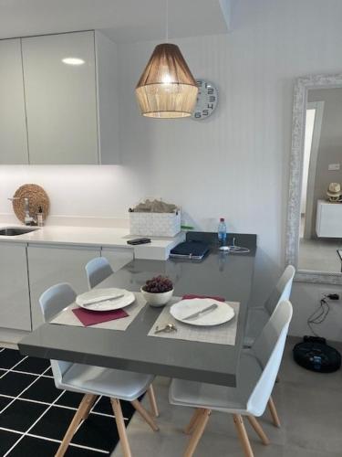a table and chairs in a kitchen with a table and a counter at Viente Cien in San Javier