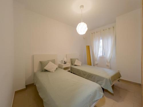 2 camas en una habitación blanca con ventana en Apartamento Faro Beach by Solset en Torre del Mar
