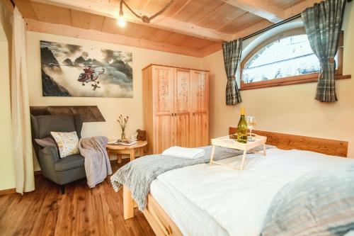 um quarto com uma cama, uma cadeira e uma janela em Tatra Góral Ski Apartament em Murzasichle