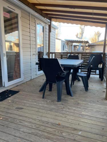 a patio with a table and chairs on a deck at Camping la carabasse mobilhome 4/6 personnes in Vias
