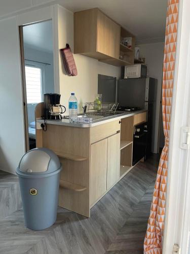 a small kitchen with a trash can and a counter at Camping la carabasse mobilhome 4/6 personnes in Vias