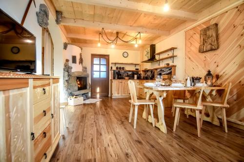 eine Küche mit einem Tisch und Stühlen sowie einem Kamin in der Unterkunft Tatra Góral Ski Apartament in Murzasichle