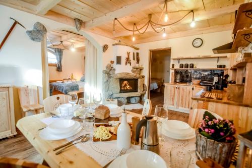 a dining room with a table and a fireplace at Tatra Góral Ski Apartament in Murzasichle
