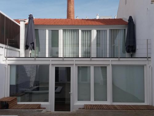 an external view of a house with a balcony at Casa do Lado - The next door in Seixal