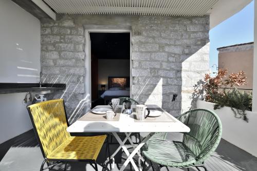 - une table et des chaises blanches sur la terrasse dans l'établissement Loft romantico con veranda, à Tortolì