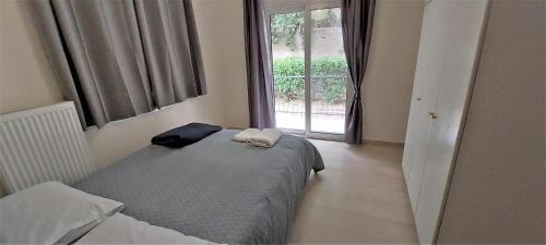 um pequeno quarto com uma cama e uma janela em Cozy apartment in Nea Smyrni em Atenas