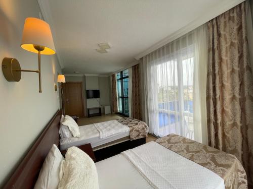 a hotel room with two beds and a window at Admiral Hotel in Kizkalesi