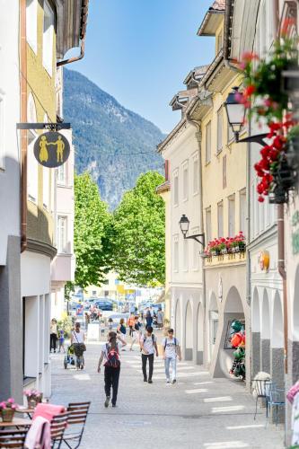a group of people walking down a street with buildings at Bergpanorama in Bludenz