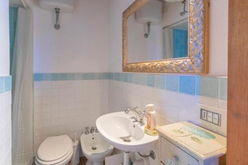 a bathroom with a sink and a toilet and a mirror at Capo Bianco Studio by HelloElba in Portoferraio