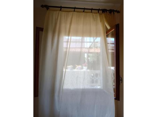 a window with a white curtain in a room at Calabrian Home in Casa Roccani