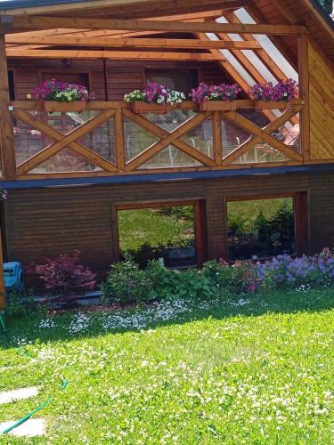 a house with a wooden roof with flower boxes on it at Mária Kičáková TATRY MKS in Štrba