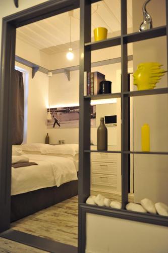 a bedroom with a bed and a room with a mirror at Hydra Icons in Hydra