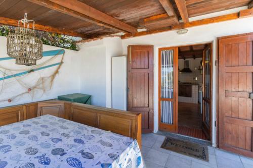 a bedroom with a bed and a door to a kitchen at Capo Bianco Studio by HelloElba in Portoferraio