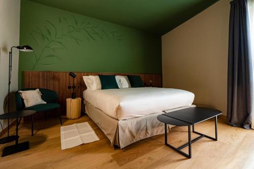 a bedroom with a bed and a green wall at Locanda Moderna Carlambroeus in Montevecchia