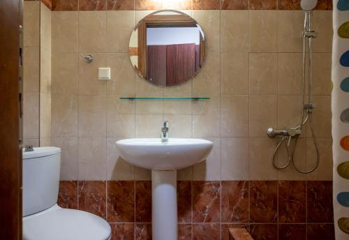 a bathroom with a sink and a toilet and a mirror at Sunset Studios in Toroni