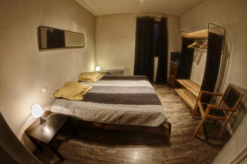 1 dormitorio con 1 cama, TV y silla en kiné lounge, en Bazet